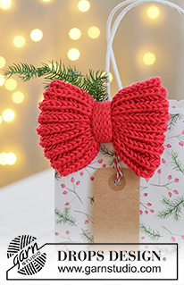 Holly Red Bow / DROPS Extra 0-1628 - Prjónuð slaufa / jólaskraut úr DROPS Cotton Merino. Stykkið er prjónað frá hlið að hlið í klukkuprjóni með i-cord og tvöföldu prjóni. Þema: Jól.
