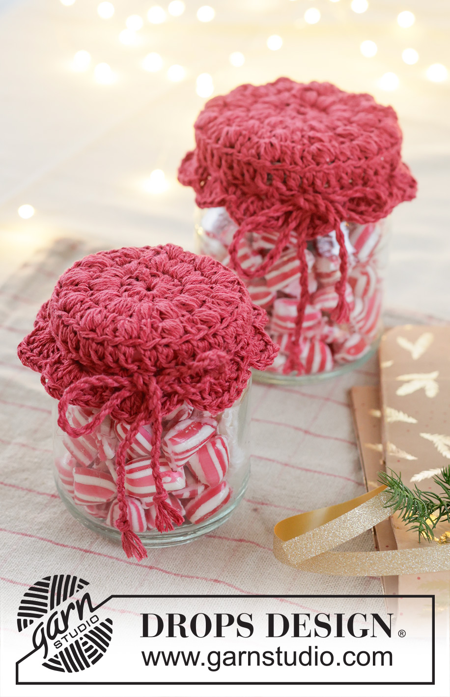 Holiday Jar Keeper / DROPS Extra 0-1629 - Crocheted jam jar cover in DROPS Belle. The piece is worked in the round, middle outwards, with puff-stitches and fan pattern. Theme: Christmas.