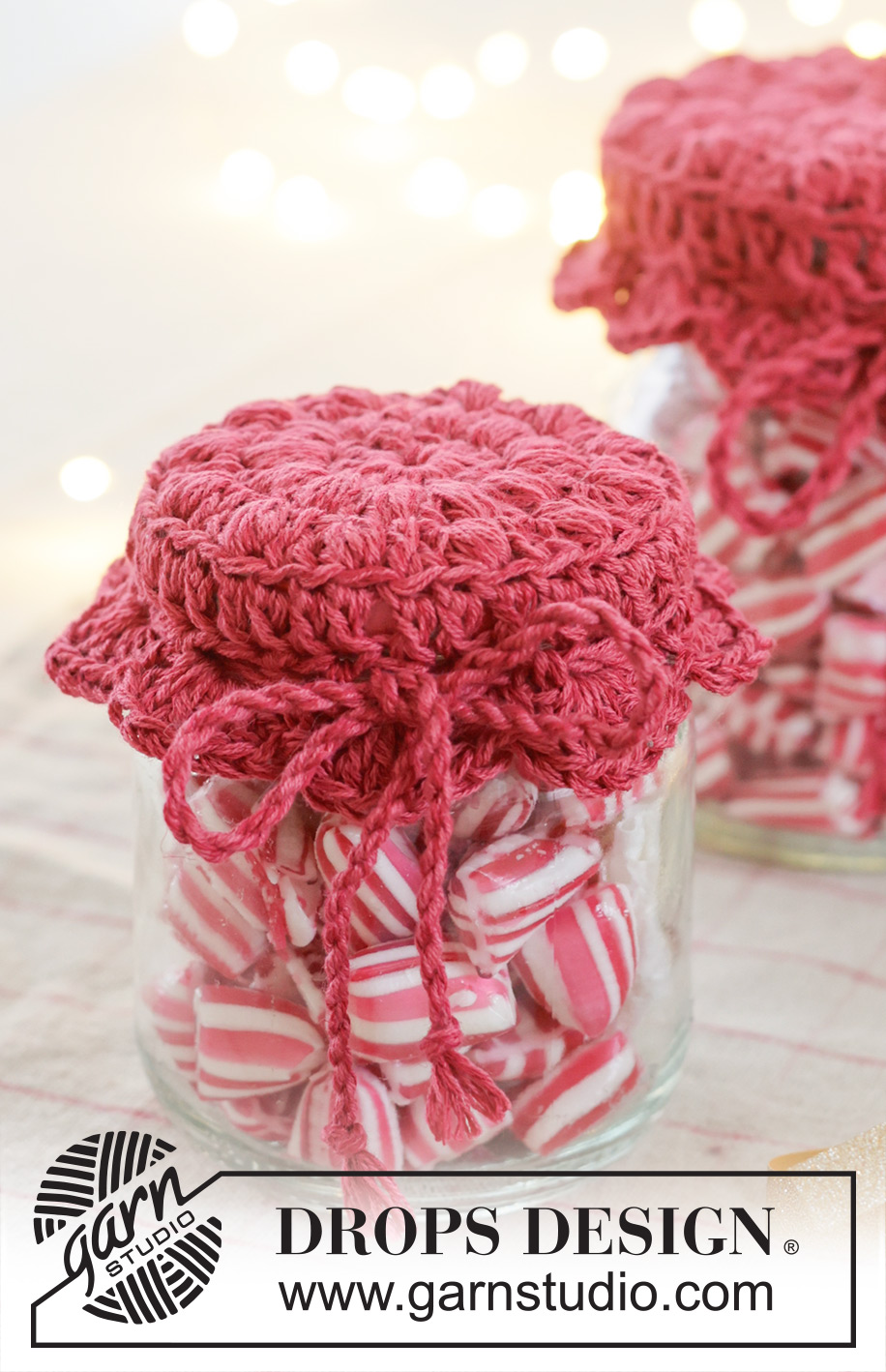 Holiday Jar Keeper / DROPS Extra 0-1629 - Crocheted jam jar cover in DROPS Belle. The piece is worked in the round, middle outwards, with puff-stitches and fan pattern. Theme: Christmas.