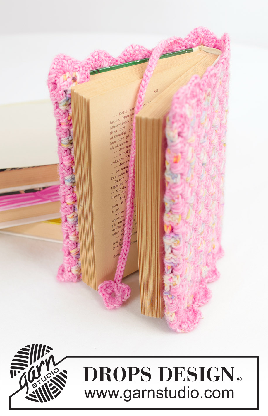 Heartfelt Sleeve / DROPS Extra 0-1655 - Crocheted book cover and bookmark in DROPS Fiesta. The piece is worked with treble-crochet groups, stripes and fan-patterned edges. Theme: Valentine.