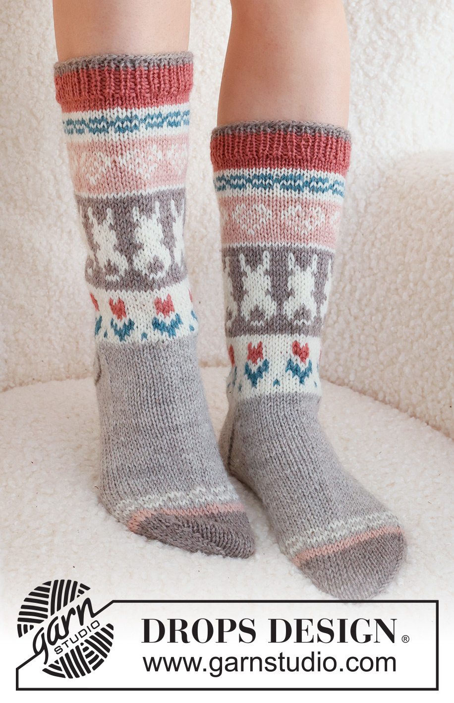 Dancing Bunny Socks / DROPS 229-34 - Strikkede sokker i DROPS Karisma. Arbeidet strikkes ovenfra og ned, i glattstrikk med flerfarget mønster med hjerte, hare / påskehare og blomst. Størrelse 35 - 46. Tema: Påske.