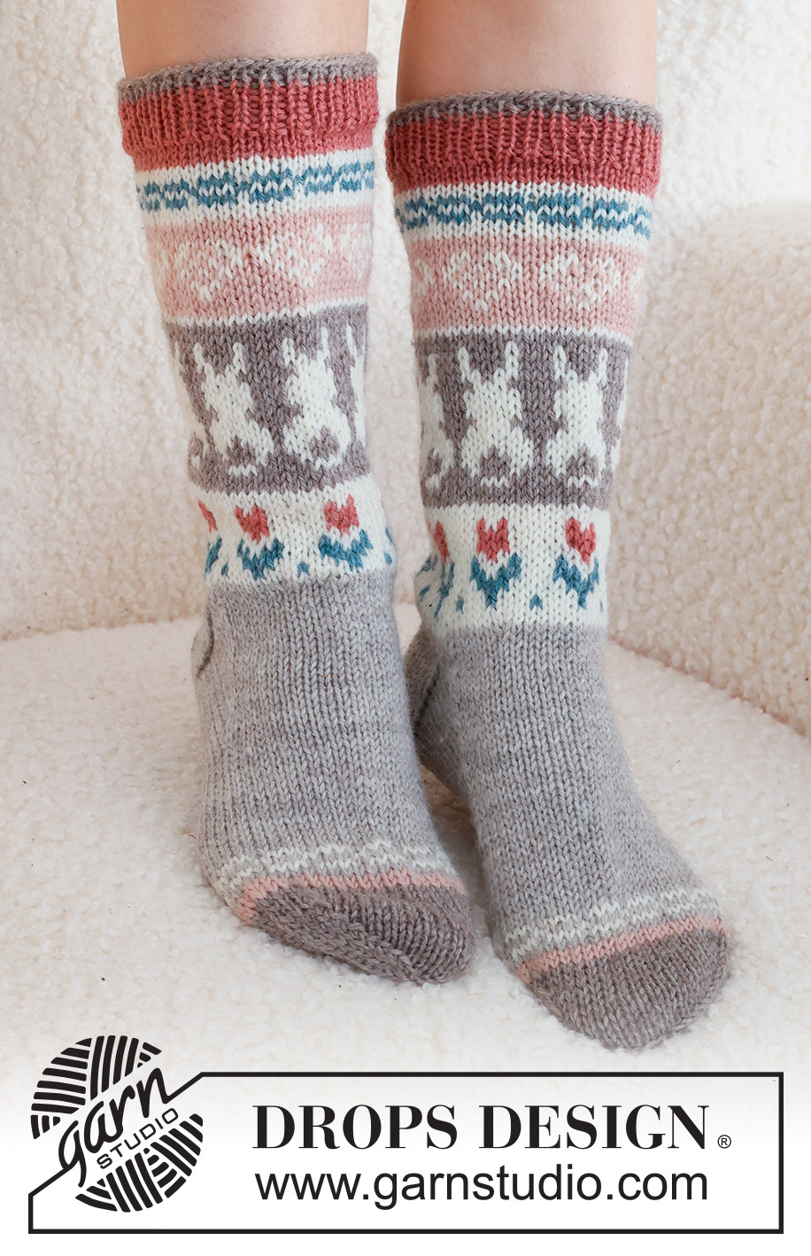 Dancing Bunny Socks / DROPS 229-34 - Strikkede sokker i DROPS Karisma. Arbeidet strikkes ovenfra og ned, i glattstrikk med flerfarget mønster med hjerte, hare / påskehare og blomst. Størrelse 35 - 46. Tema: Påske.