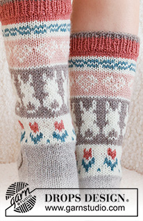 Dancing Bunny Socks / DROPS 229-34 - Strikkede sokker i DROPS Karisma. Arbeidet strikkes ovenfra og ned, i glattstrikk med flerfarget mønster med hjerte, hare / påskehare og blomst. Størrelse 35 - 46. Tema: Påske.
