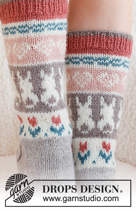 Dancing Bunny Socks / DROPS 229-34 - Strikkede sokker i DROPS Karisma. Arbeidet strikkes ovenfra og ned, i glattstrikk med flerfarget mønster med hjerte, hare / påskehare og blomst. Størrelse 35 - 46. Tema: Påske.