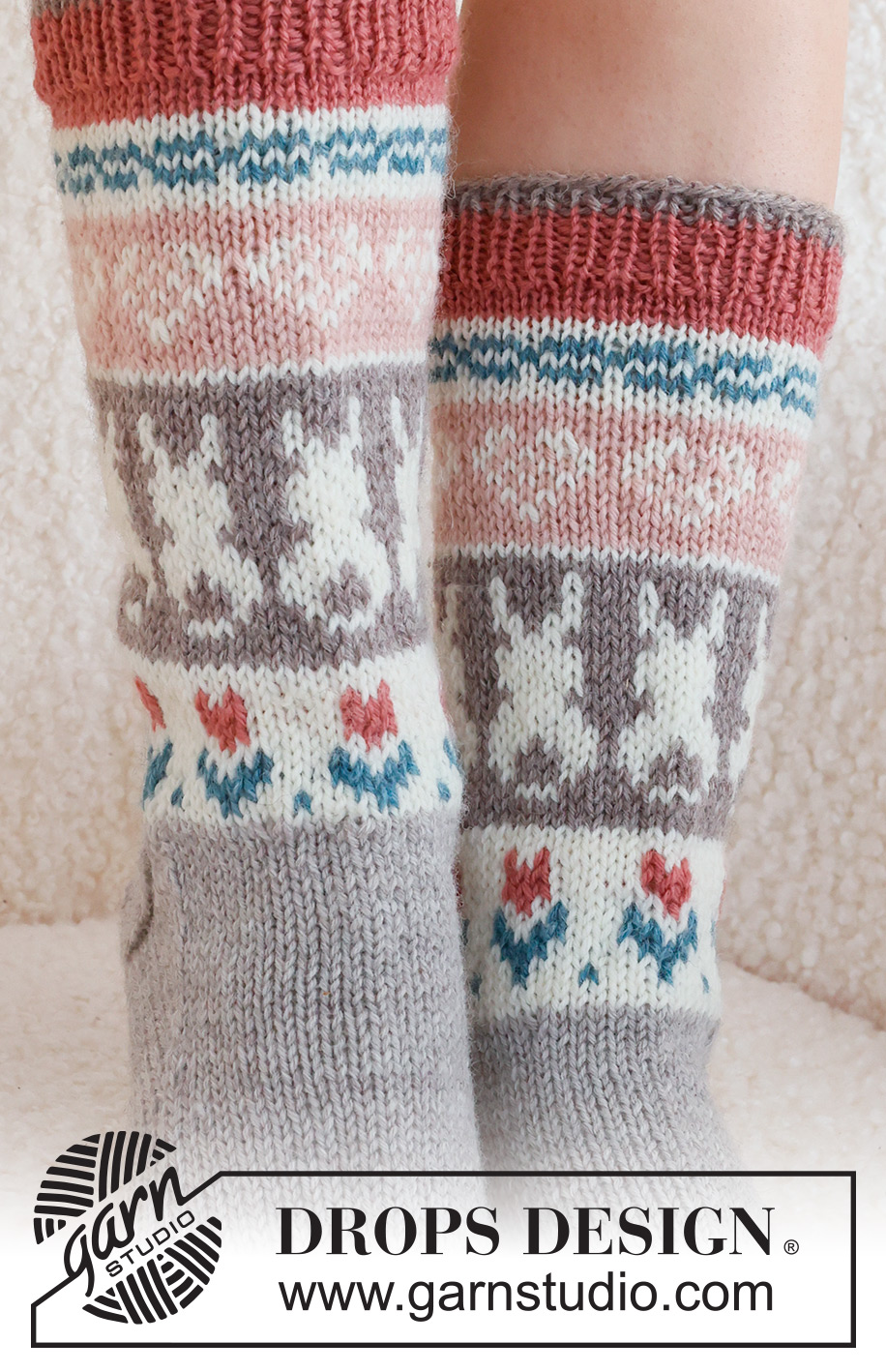 Dancing Bunny Socks / DROPS 229-34 - Strikkede sokker i DROPS Karisma. Arbeidet strikkes ovenfra og ned, i glattstrikk med flerfarget mønster med hjerte, hare / påskehare og blomst. Størrelse 35 - 46. Tema: Påske.