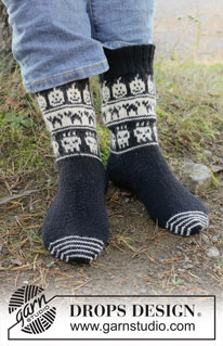 Boo-tiful Feet / DROPS 253-54 - Knitted socks in DROPS Nord. The piece is worked from the toe upwards, with heel-gusset and two-coloured pattern of cats, pumpkins and skulls. Sizes 35-43. Theme: Halloween.