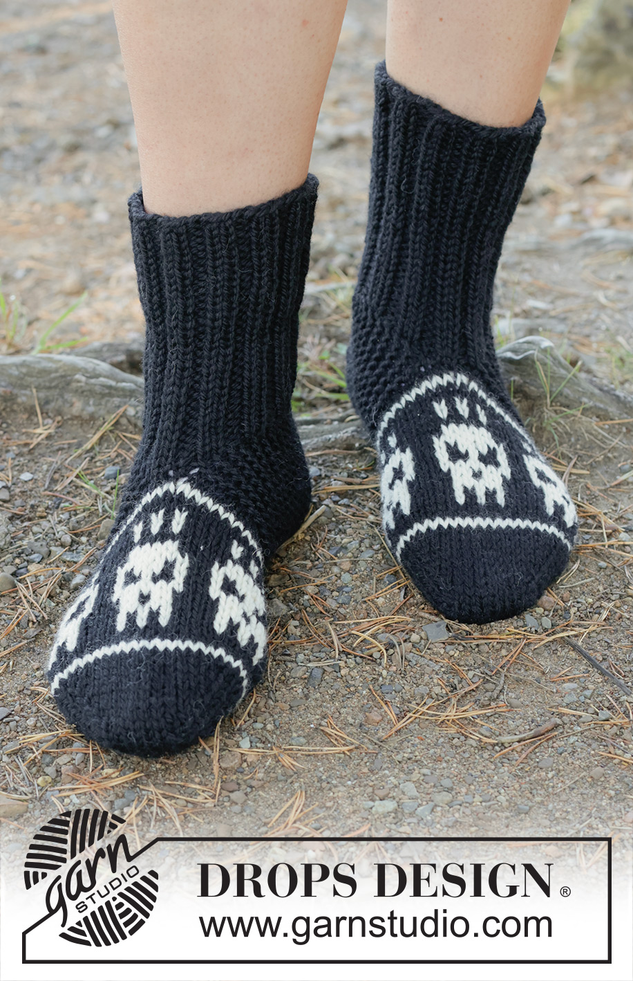 Spooky Toes / DROPS 253-56 - Knitted slippers in DROPS Alaska. Piece is worked from the toe and up with multi-coloured pattern with skulls. Size 35-43. Theme: Halloween.