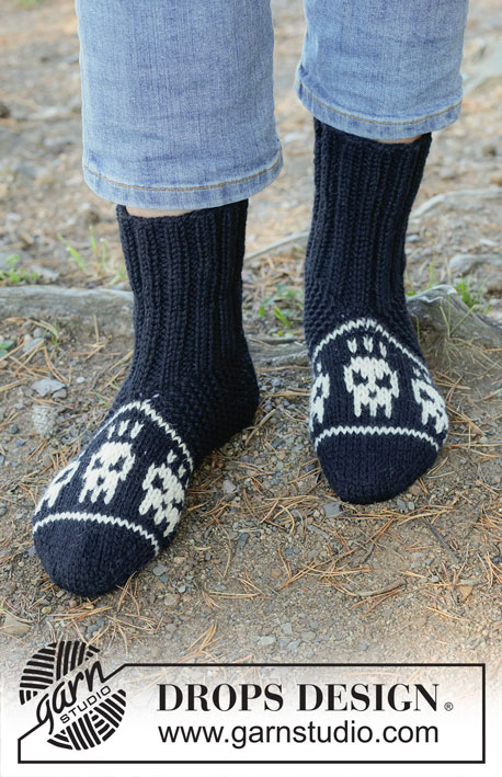 Spooky Toes / DROPS 253-56 - Knitted slippers in DROPS Alaska. Piece is worked from the toe and up with multi-coloured pattern with skulls. Size 35-43. Theme: Halloween.