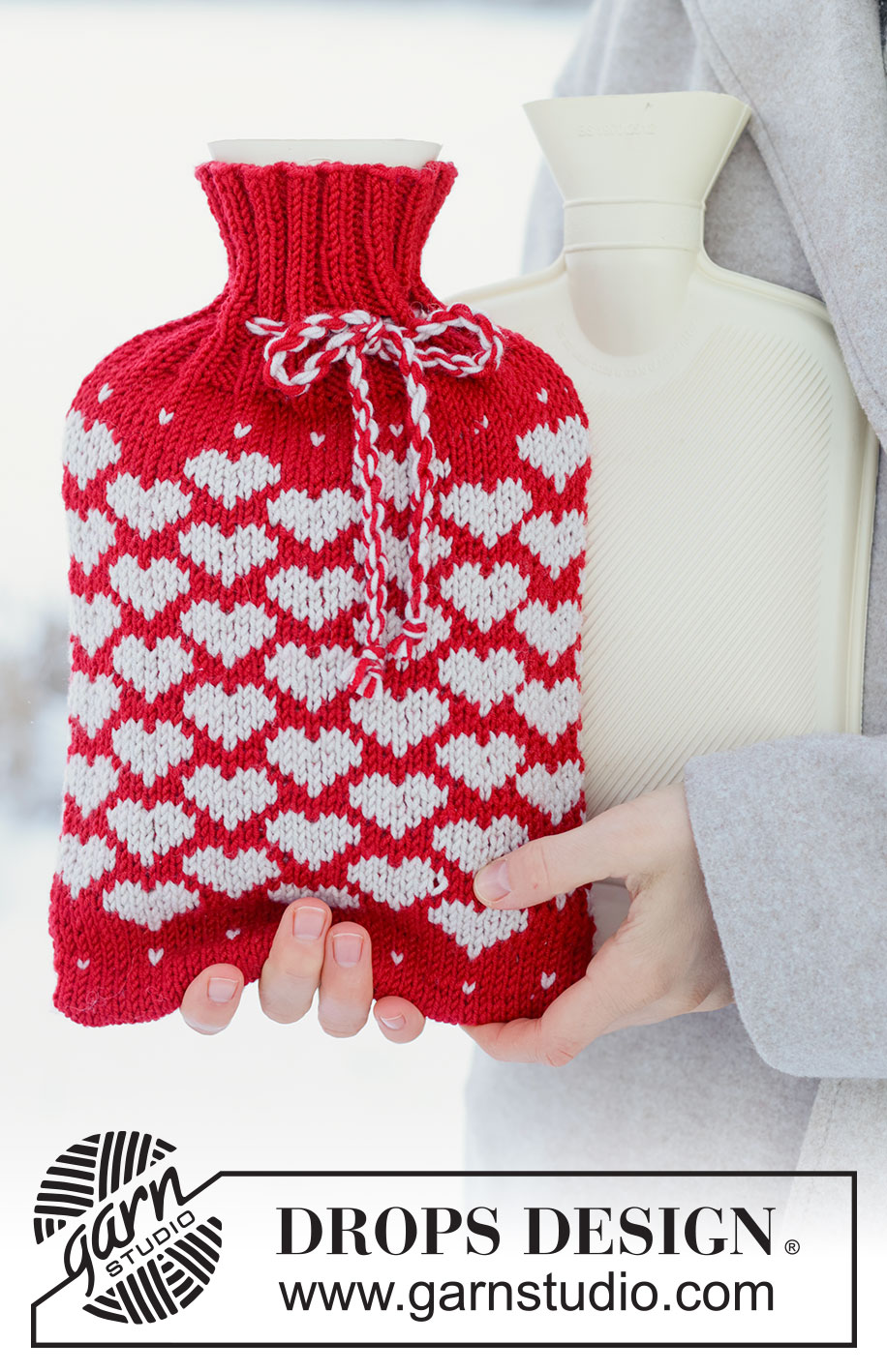 Snuggle Hearts / DROPS 261-76 - Pokrowiec na termofor na drutach z włóczki DROPS Merino Extra Fine. Przerabiany od dołu do góry dżersejem i żakardem norweskim w serca. Temat: Walentynki.