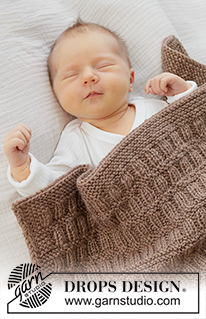 Cocoa Dream Blanket / DROPS Baby 51-2 - Gestrickte Decke für Babys in DROPS Karisma. Die Arbeit wird in Hin- und Rück-Reihen mit Reliefmuster und I-Cord gestrickt.