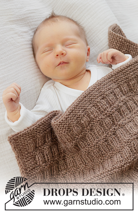 Cocoa Dream Blanket / DROPS Baby 51-2 - Gestrickte Decke für Babys in DROPS Karisma. Die Arbeit wird in Hin- und Rück-Reihen mit Reliefmuster und I-Cord gestrickt.