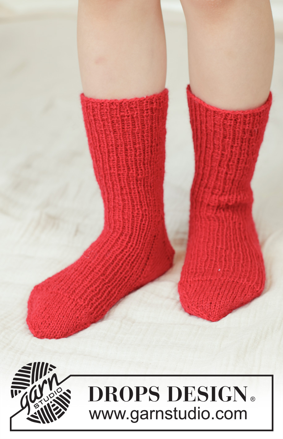 Merry Mistletoe Socks / DROPS Children 48-22 - Gestrickte Socken für Kinder in DROPS Fabel. Die Arbeit wird von oben nach unten mit Rippenmuster gestrickt. Größe 24 - 43.