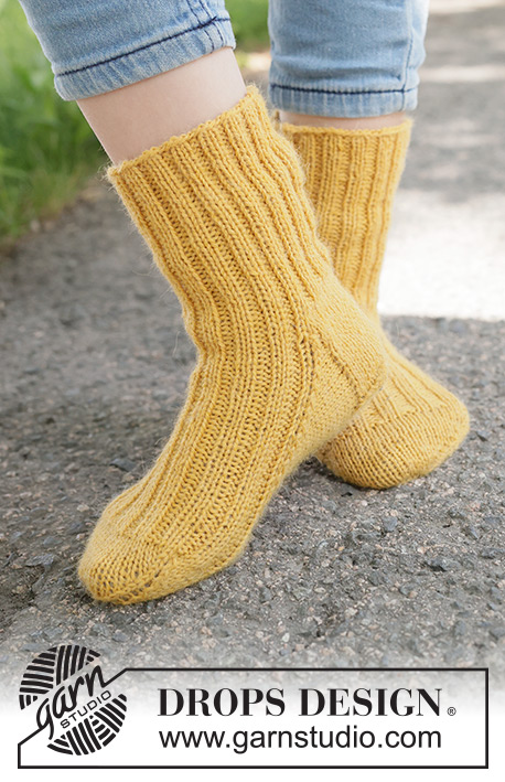Dandelion Days Socks / DROPS Children 49-26 - Strikkede sokker til barn i DROPS Nord. Arbeidet strikkes ovenfra og ned med vrangbord. Størrelse 24 - 43.