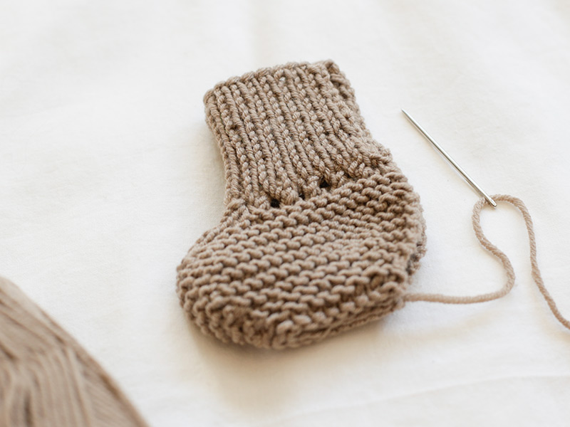 Baby bootie and needle